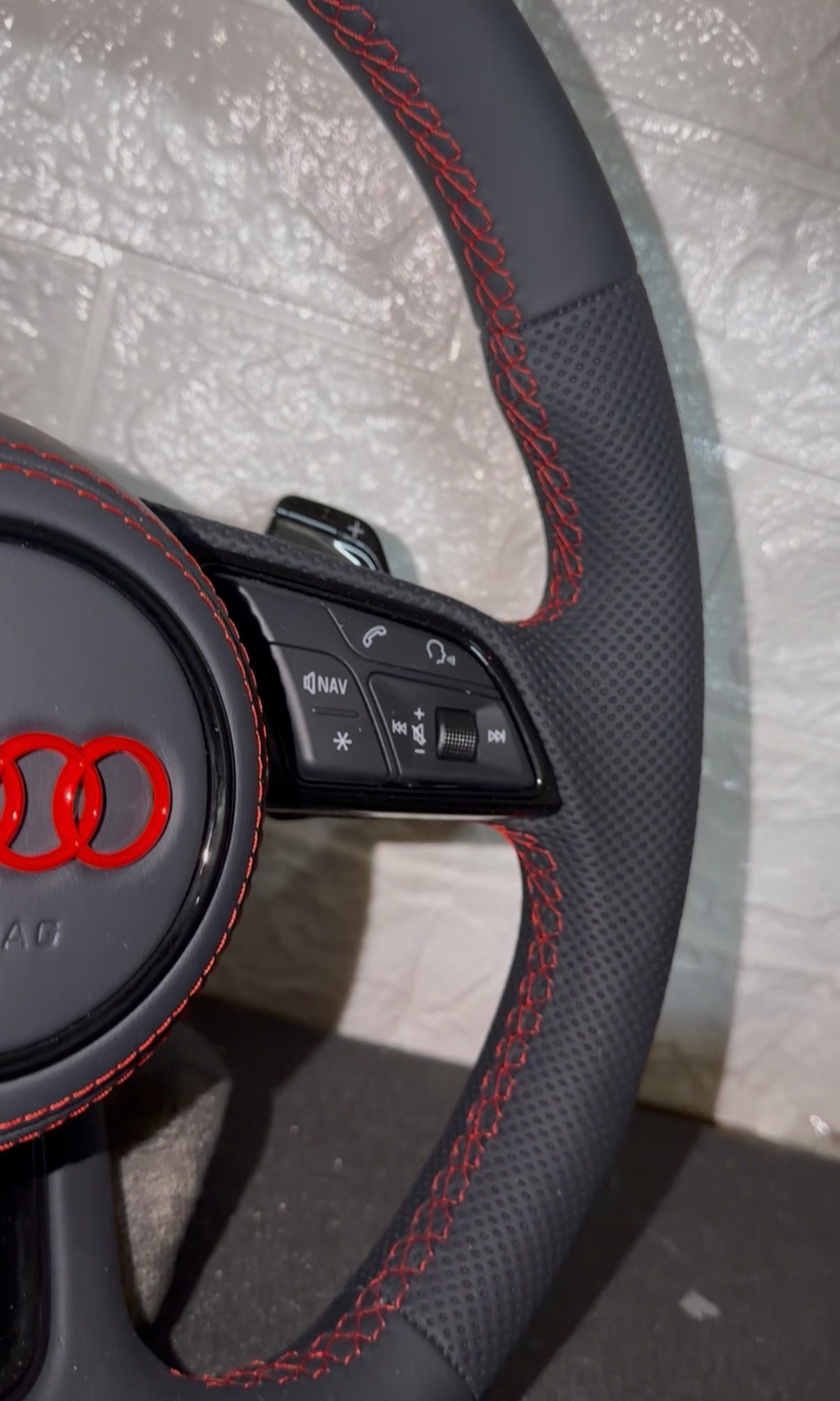 Volante audi con cuciture rosse, logo rosso, mirino rosso e paddle al volante