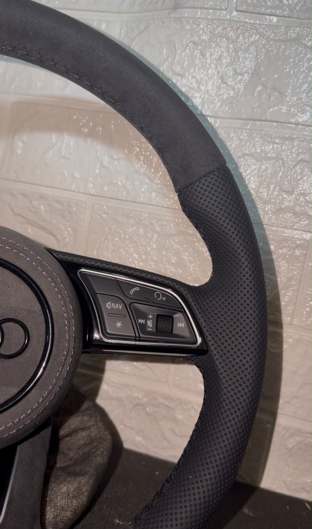 Volante con alcantara e pelle trafortata , con tasti multifunzione e cuciture nere