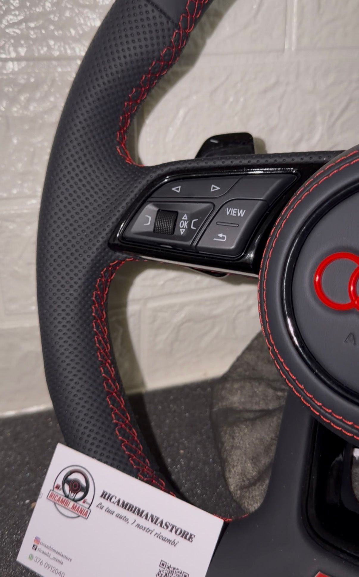 Volante audi con cuciture rosse, logo rosso, mirino rosso e paddle al volante