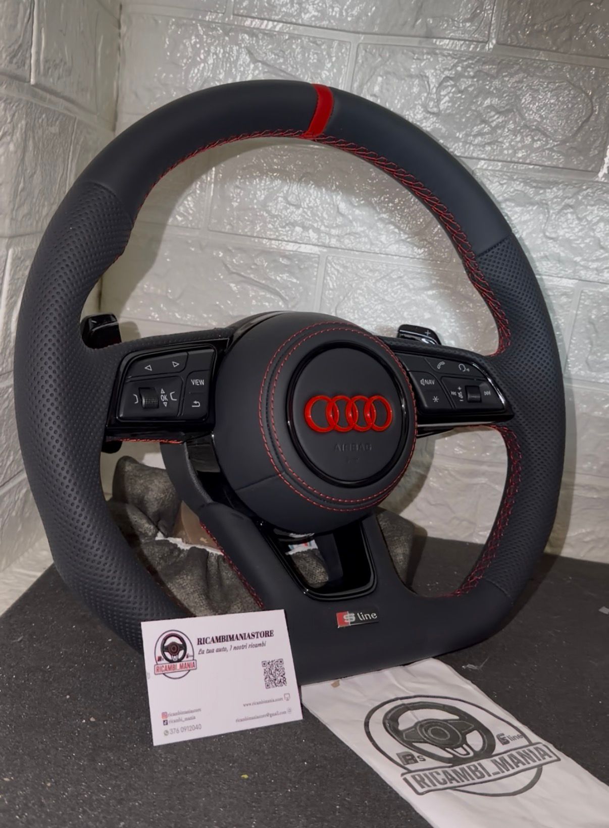 Volante audi con cuciture rosse, logo rosso, mirino rosso e paddle al volante