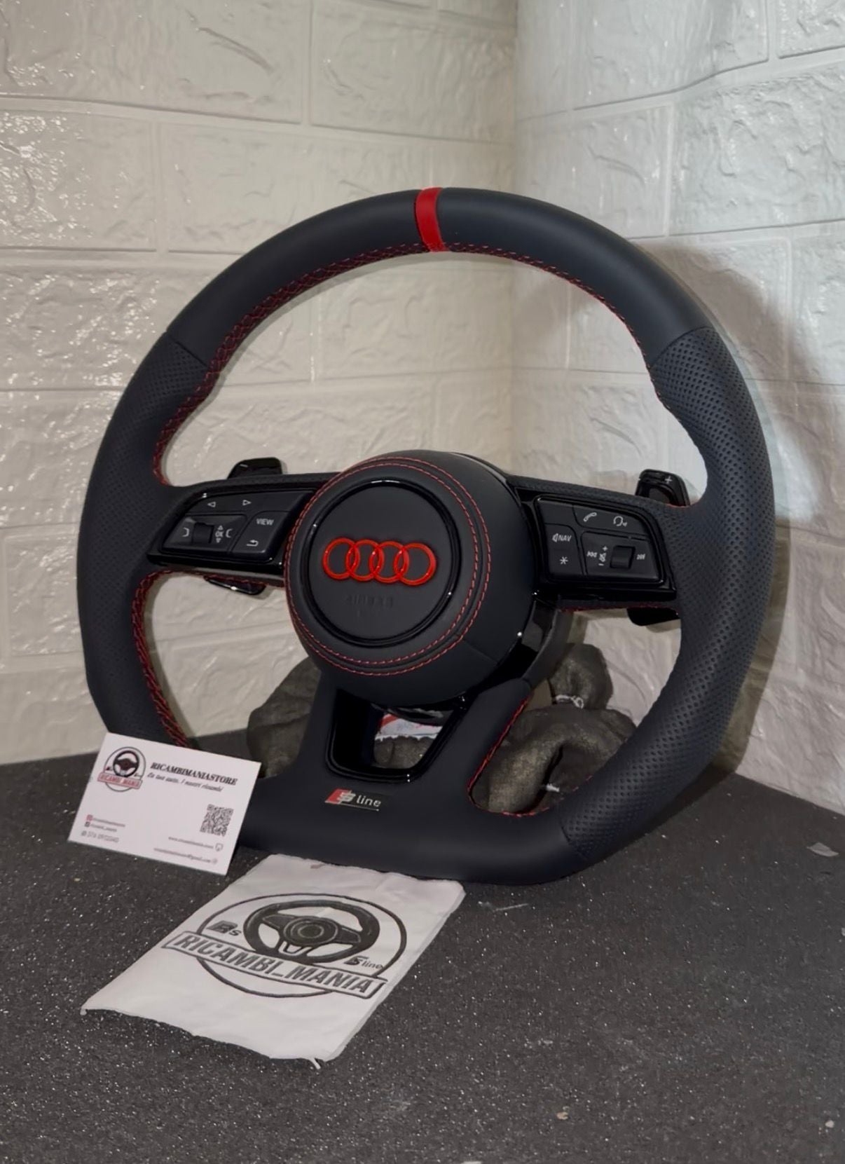Volante audi con cuciture rosse, logo rosso, mirino rosso e paddle al volante
