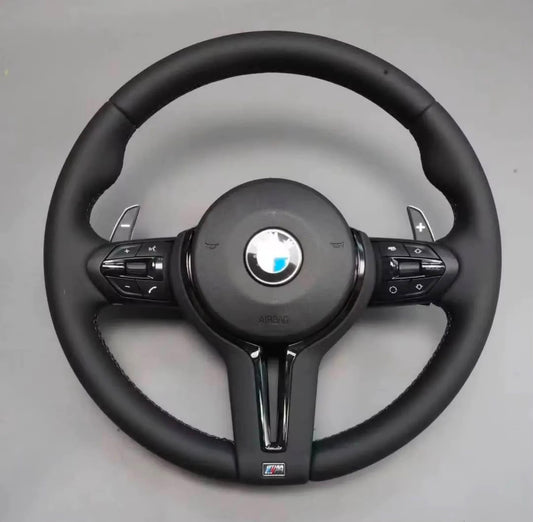 Volante bmw classico con finiture nere lucide, tasti multifunzione, paddle al volante